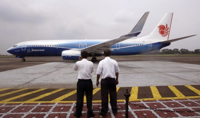 Officials watch a new Lion Air Boeing 737-900 ER series passenger jet during its official launch in Jakarta.