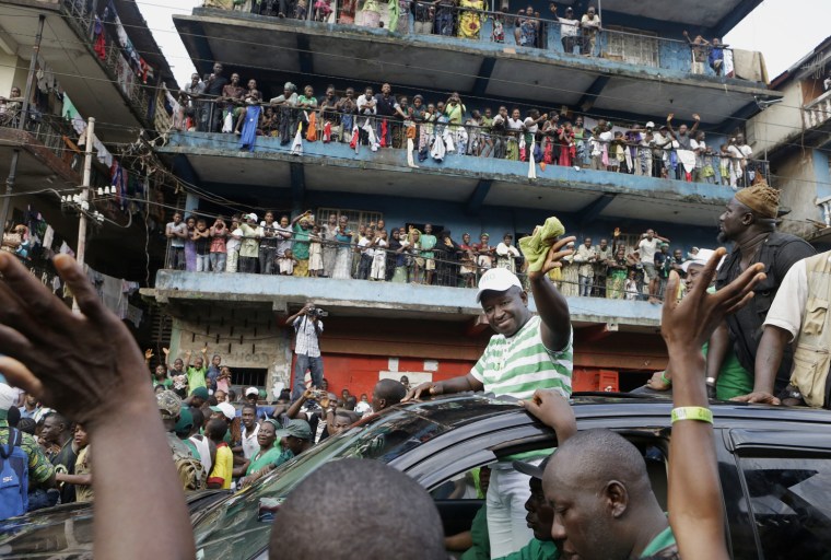 Opposition candidate Julius Maada Bio waves to supporters as his campaign convoy drives through the Kissy neighborhood, en route to his final campaign rally in Freetown, Sierra Leone, Nov. 15.