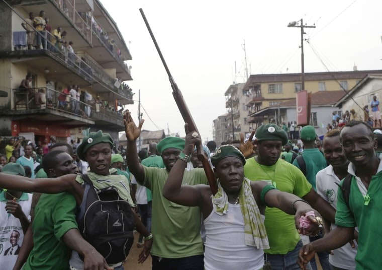 Supporters of opposition candidate Julius Maada Bio fill the street as his campaign convoy drives through the Kissy neighborhood, en route to Bio's final campaign rally in Freetown, Sierra Leone, Nov. 15. A few supporters displayed symbolic, or real, guns to symbolize the laying down of arms in favor of a non-violent election process.
