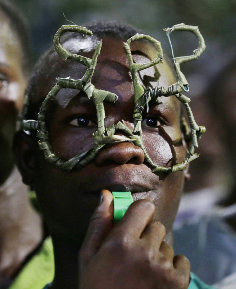 A Sierra Leone People's Party supporter wears glasses made of wire and reeds in the shape of the party's initials at the final campaign rally for candidate Julius Maada Bio, in Freetown, Nov. 15.
