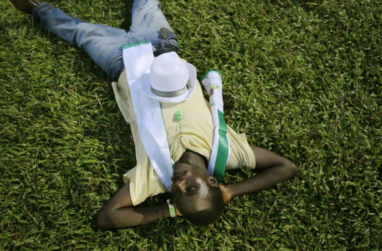 A supporter of opposition candidate Julius Maada Bio rests on a stadium field as he waits for Bio to arrive at his final campaign rally in Freetown, Sierra Leone, Nov. 15.