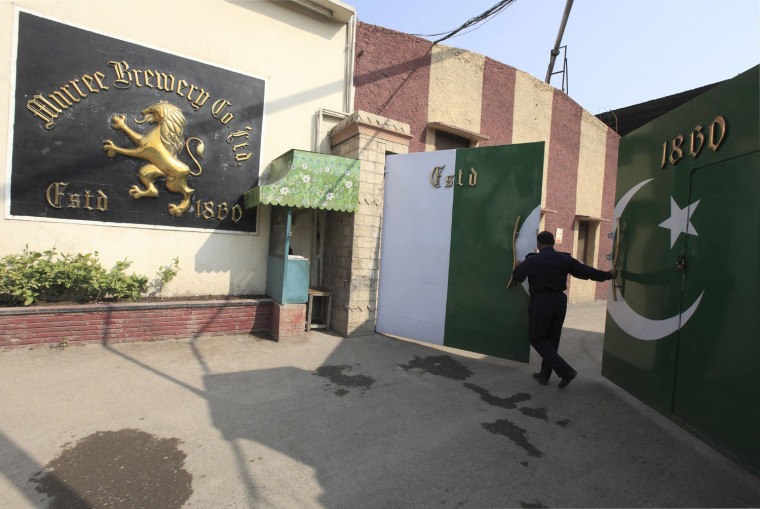 A Murree Brewery guard closes the factory's main gate in Rawalpindi, Pakistan, Nov. 10.