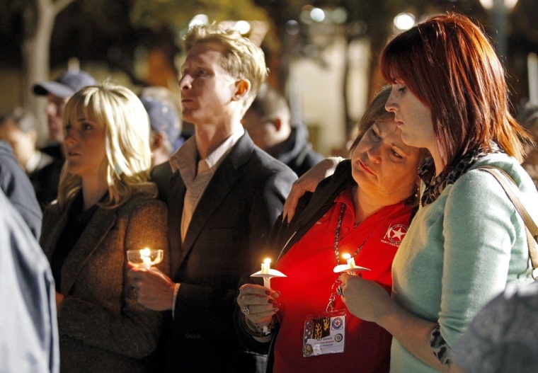 People gather in Centennial Plaza in Midland, Texas, on Saturday for a candlelight vigil held in honor of four veterans who were killed when a freight train hit a parade float.