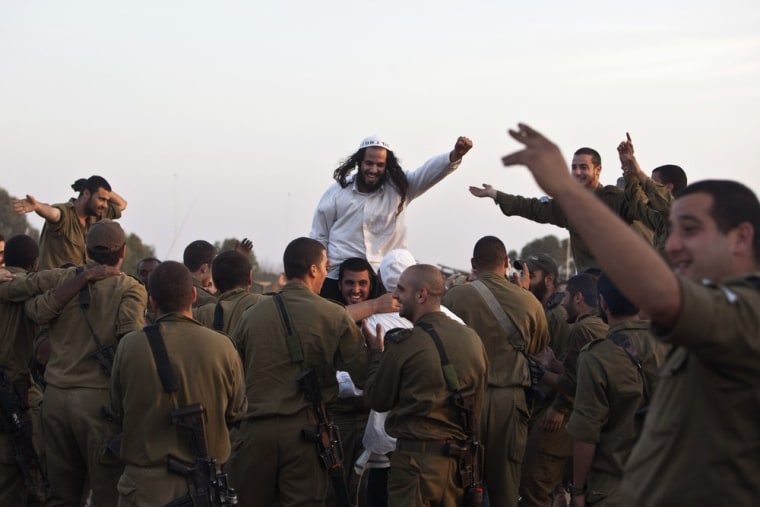 A Hasidic Jewish man, from the Breslov sect, is carried on the shoulders of an Israeli soldier during a visit to support the troops, near the border with the Gaza Strip November 19, 2012. Israel bombed dozens of targets in Gaza on Monday and said that while it was prepared to step up its offensive by sending in troops, it preferred a diplomatic solution that would end Palestinian rocket fire from the enclave. REUTERS/Nir Elias (ISRAEL - Tags: POLITICS CIVIL UNREST MILITARY RELIGION TPX IMAGES OF THE DAY)