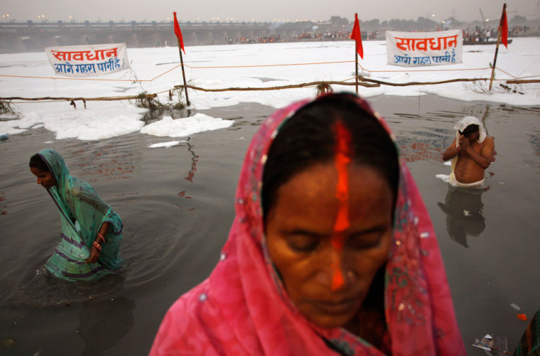 Indian Hindu devotees offer prayers to the sun god on the occasion of Chhath Puja festival at Yamuna river in New Delhi, India, on Nov. 19. On Chhath, an ancient Hindu festival, rituals are performed to thank the sun god for sustaining life on earth. The banner reads as