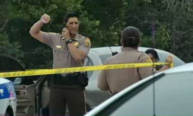 Police officers investigate the scene of a school bus shooting on Tuesday in Homestead, Fla.