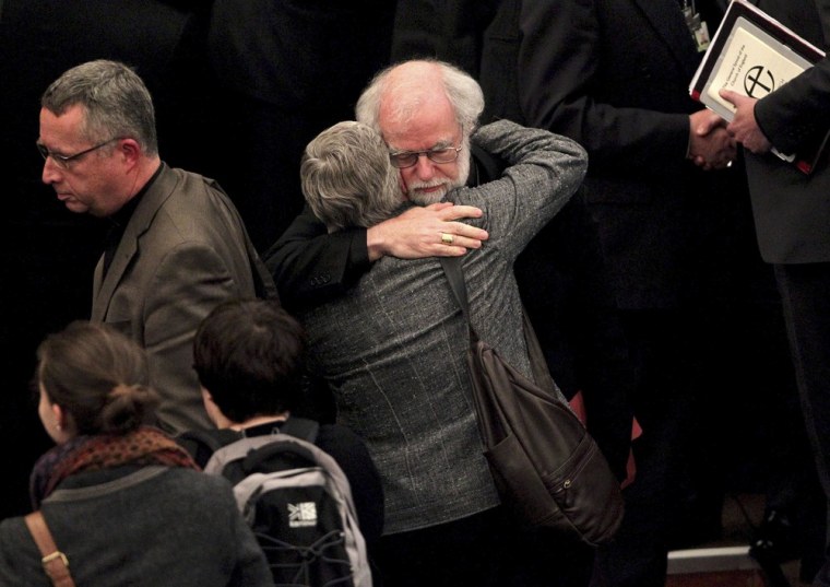 The outgoing Archbishop of Canterbury Rowan Williams, center right, embraces an unidentified person after draft legislation introducing the first women bishops in the Church of England failed to receive final approval from the Church of England General Synod, at Church House in central London, on Nov. 20.