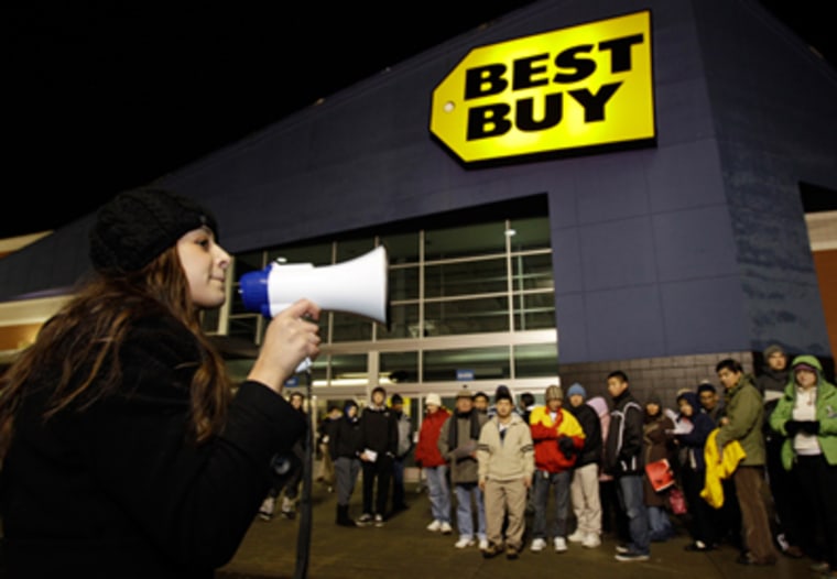 Lucia Valenuela uses a bullhorn to give instructions to crowds of shoppers lined up in the early hours of the Black Friday shopping day, Nov. 26, 2010, at Best Buy in Tacoma, Wash.