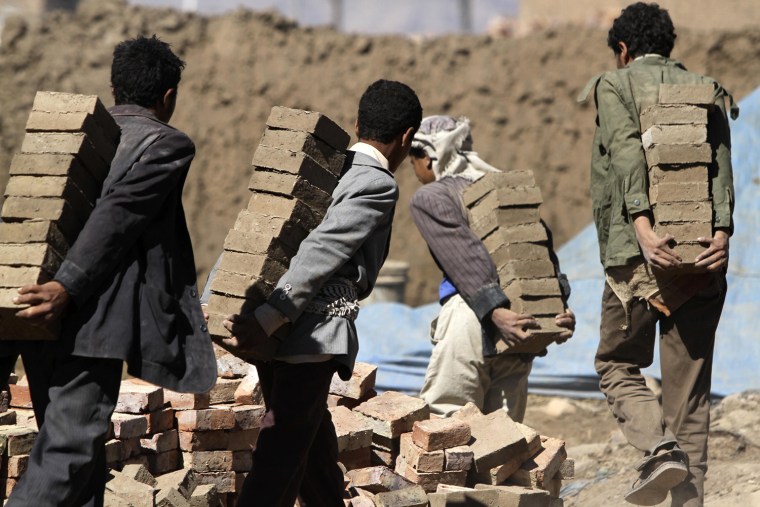 Workers carry dried mud bricks to a kiln at a traditional brick-manufacturing site in San'a, Yemen, Nov. 20.
