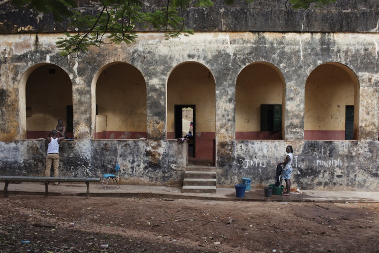 A woman washes clothes in front of a colonial-era building on the island of Bolama, Guinea-Bissau, Nov. 5.