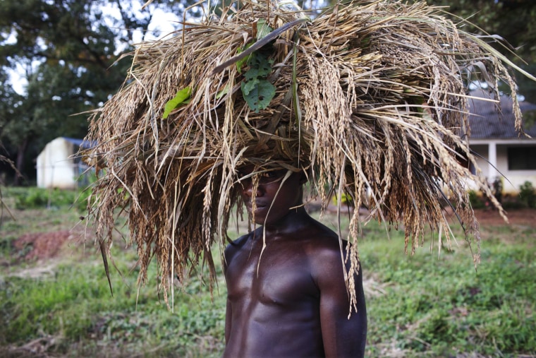 A farmer, carrying wheat on his head, poses for a picture as he walks home after a day's work in Guiledge, Guinea-Bissau, Nov. 3. Guiledge was a stronghold of the Portuguese army and its fall to anti-colonial rebels in early 1973 marked the final stages of Portuguese rule.