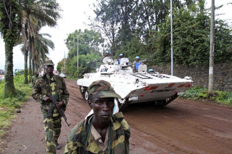 A United Nations peacekeepers' armored vehicle drives past rebels patrolling a street in Goma in the eastern Democratic Republic of Congo after they captured the city from the government army on Tuesday.