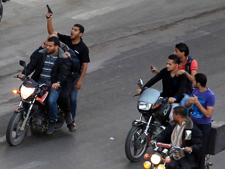 Palestinian gunmen ride motorcycles as they drag the body of a man, who was suspected of working for Israel, in Gaza City, Tuesday.
