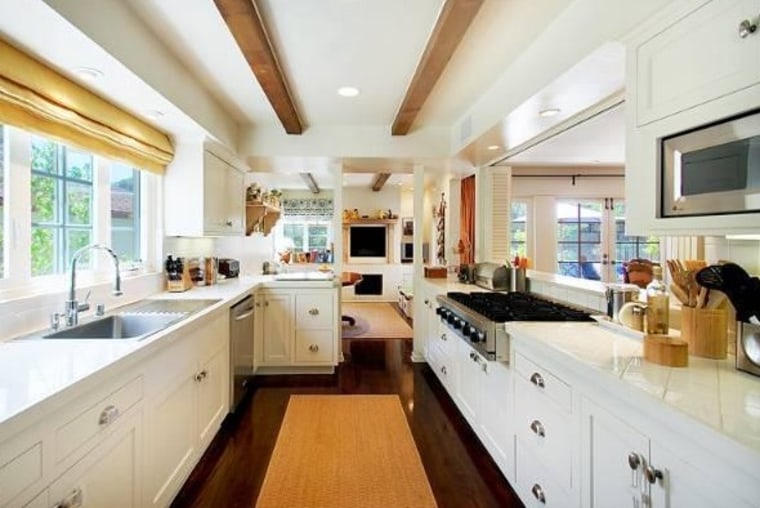 The galley-style kitchen in Emma Stone's new Beverly Hills home has white tiled countertops, stainless steel appliances and a large sink with built-in...