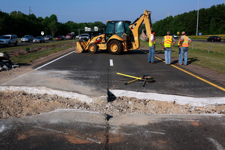 North Carolina Division of Highway workers wait for asphalt to arrive after removing a section of westbound I-440 that buckled in triple-digit temperatures over the summer.