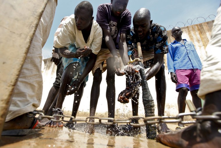 Shackled inmates wash their hands and feet at a yard in Rumbek Central Prison in Rumbek, South Sudan, Oct. 24.