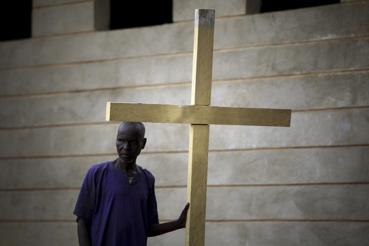 An elderly inmate leans against a cross at a yard inside the Rumbek Central Prison in Rumbek, South Sudan, Oct. 25.