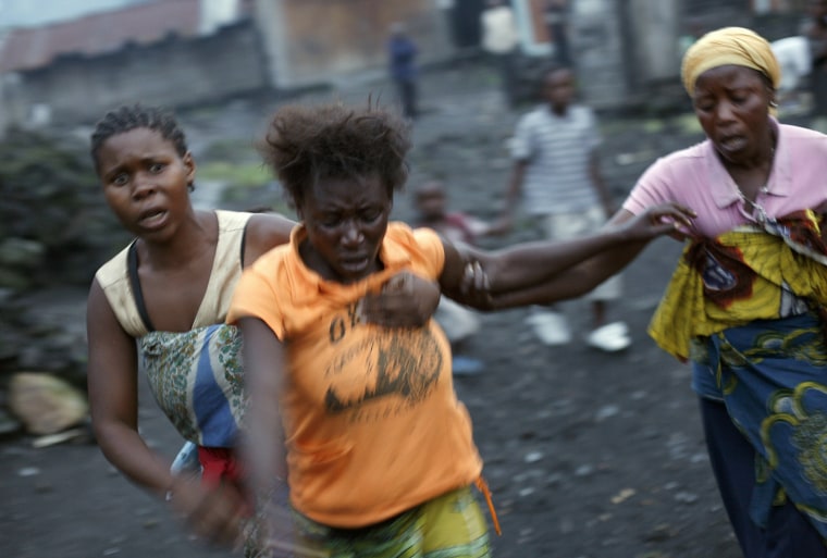 Women run after Congolese soldiers and rebel fighters battle over the eastern Congolese town of Sake, Nov. 22. The woman in orange, identified as Mamou, said she lost her husband by a fatal wound to the head from incoming mortar rounds. Thousands fled the M23 controlled town as the militants seeking to overthrow the government vowed to push forward despite mounting international pressure.