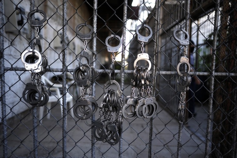 Handcuffs hang from a wire netting at La Esperaza Jail in San Salvador.