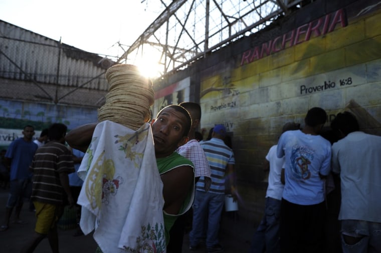 An inmate carries tortillas for breakfast at La Esperaza Jail.