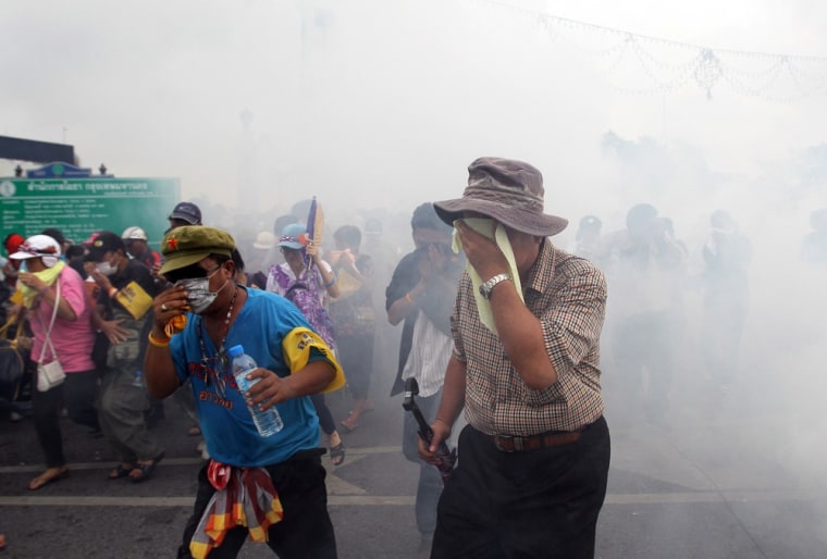 Anti-government protesters calling for Thai Prime Minister Yingluck Shinawatra to step down, protect their eyes as police fired tear gas to disperse them in Bangkok Saturday.