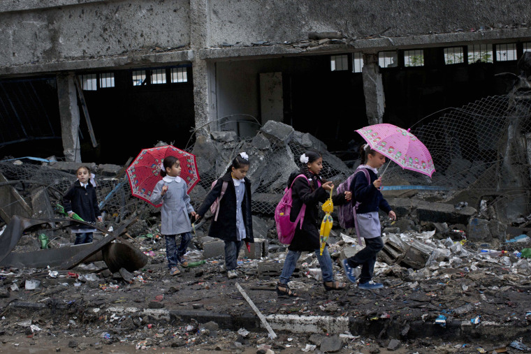 Palestinian schoolchildren walk through debris past a damaged school in Gaza City on Nov. 24, 2012. The school was damaged in an Israeli strike that targeted a nearby building.
