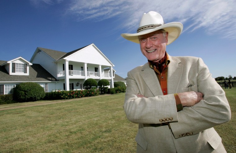 Actor Larry Hagman poses in front of the Southfork Ranch mansion made famous in the television show,