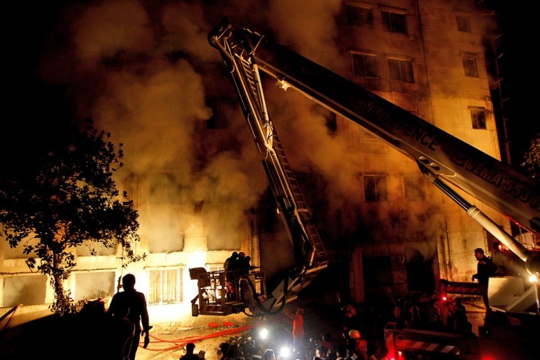 Bangladeshi firefighters battle a fire at a garment factory in the Savar neighborhood in Dhaka, Bangladesh, late Saturday.