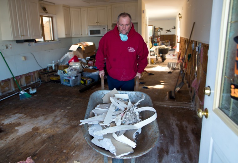 Ken Court removes sheetrock and plywood damaged by the floodwaters of Hurricane Sandy from his home in Breezy Point.