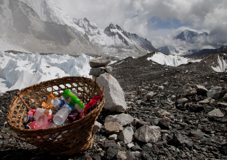 A basket of garbage sits at Everest Base Camp, with the Himalayan range seen in the background, in May 2011.