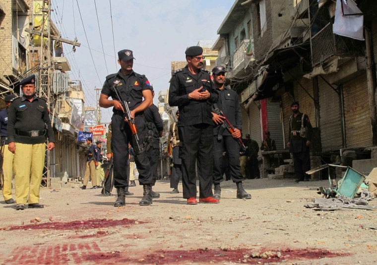 Pakistani security officials inspect the site of a bomb blast targeting a Shi'ite Muslim mourning procession in Dera Ismail Khan, Pakistan.