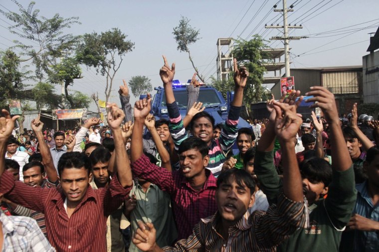 Workers shout slogans Monday as they protest against the death of their colleagues after a weekend fire in a garment factory in Savar, Bangladesh, killed more than 100 people.