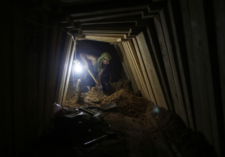 A Palestinian worker shovels sand as he repairs a damaged smuggling tunnel dug beneath the Egyptian-Gaza border in Rafah, in the southern Gaza Strip on November 26, 2012.