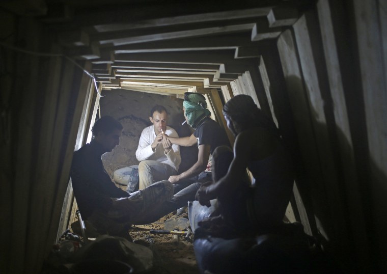 Palestinians take a cigarette break as they work inside a smuggling tunnel beneath the Egyptian-Gaza border in Rafah.