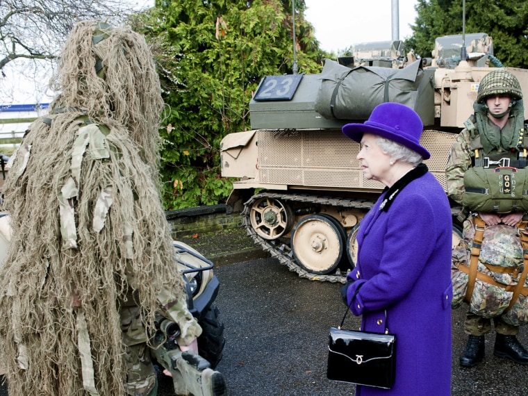 Looking a bit befuddled, Queen Elizabeth II meets a camouflaged sniper from the Household Cavalry at Combermere Barracks on Nov. 26 in Windsor, England.