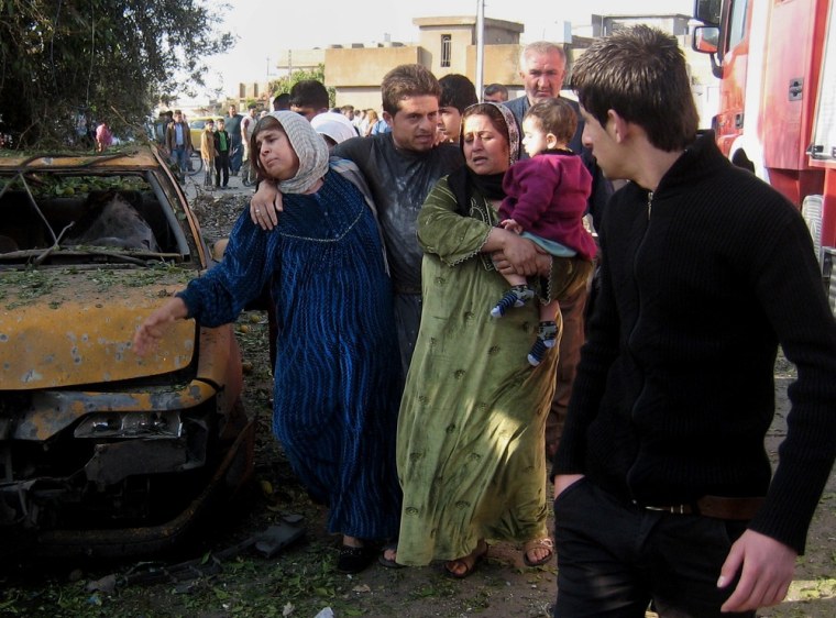 People react at the scene of a bomb attack in Kirkuk, Iraq on Nov. 27, 2012. Three parked car bombs exploded Tuesday morning simultaneously in the city of Kirkuk, home to a combustible mix of Kurds, Sunni Arabs and Turkomen who all claim rights to the city, police said.
