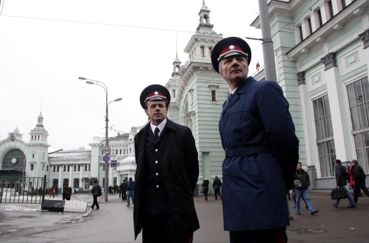 Two Cossacks watch pedestrians passing by as they patrol Belorussky railway station on Nov. 27, 2012.
