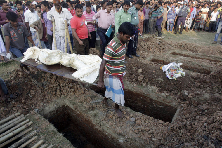 Workers bury the body of an unidentified garment worker at a graveyard in Dhaka Nov. 27.