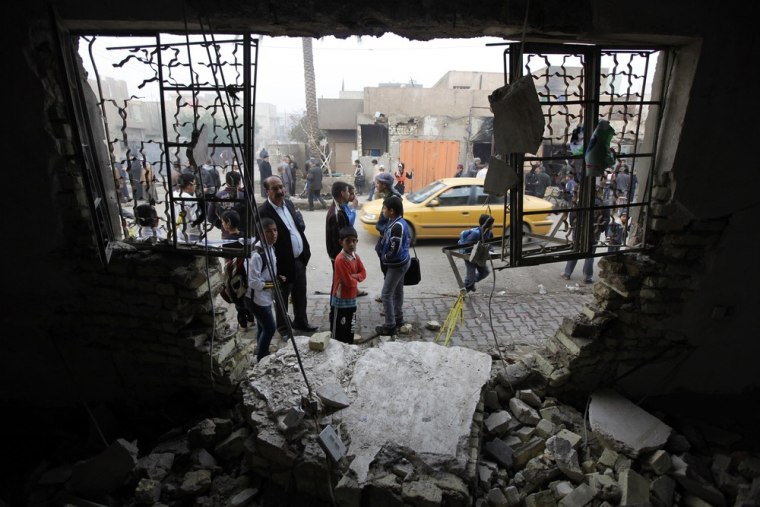 Residents gather at the site of a car bomb attack in the Shuala district of Baghdad on Nov. 28, 2012.