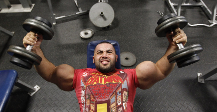 Ismail lifts weights during his daily workout.