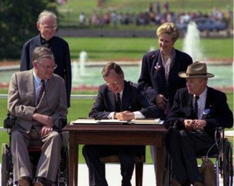 George H.W. Bush signs the Americans with Disabilities Act into law in 1990.