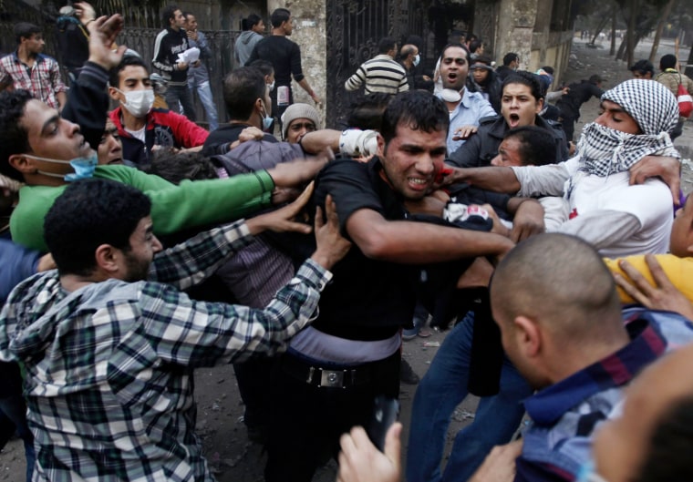 Protesters hit a riot policeman, center, after surrounding him during clashes in front of the U.S Embassy near Tahrir Square in Cairo on Nov. 28.