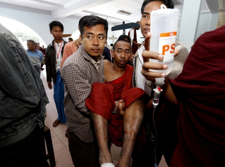 An injured monk is carried into the Monywa hospital after being injured during a demonstration outside the Latpadantaung copper mine on Nov. 29, 2012.