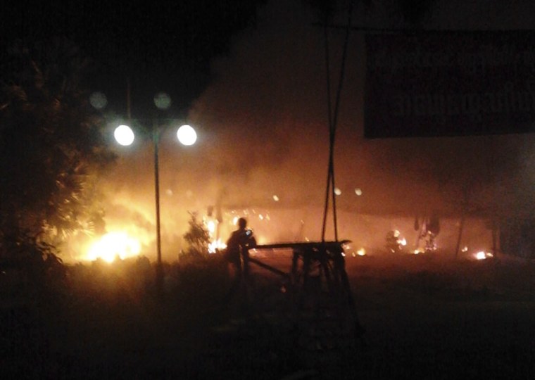 In this early Nov. 29, 2012 photo provided by a monk, flames are seen at the gate of Chinese mining partner Wan Bao where protesters occupying a copper mine camped before a police crackdown in Monywa, northwestern Myanmar.