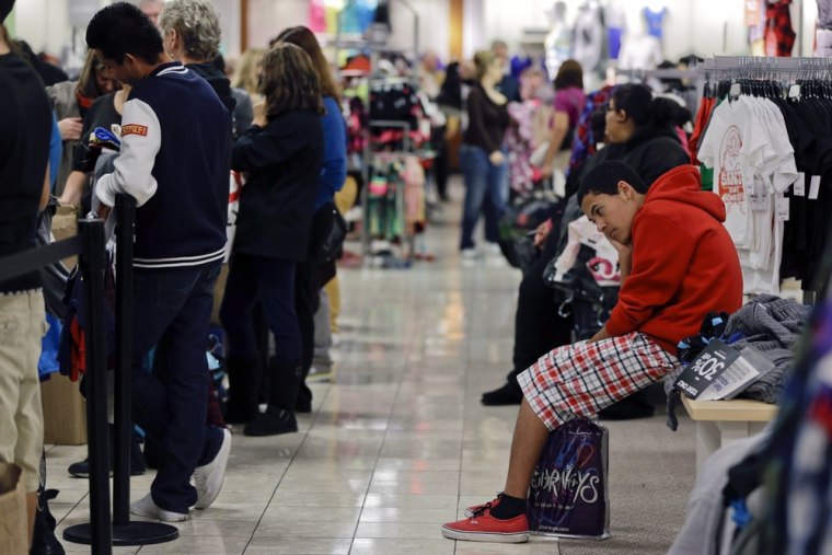 In this Friday, Nov. 23, 2012, file photo, a teenage boy waits for his family to finish shopping at a J.C. Penney store in Las Vegas. Black Friday.