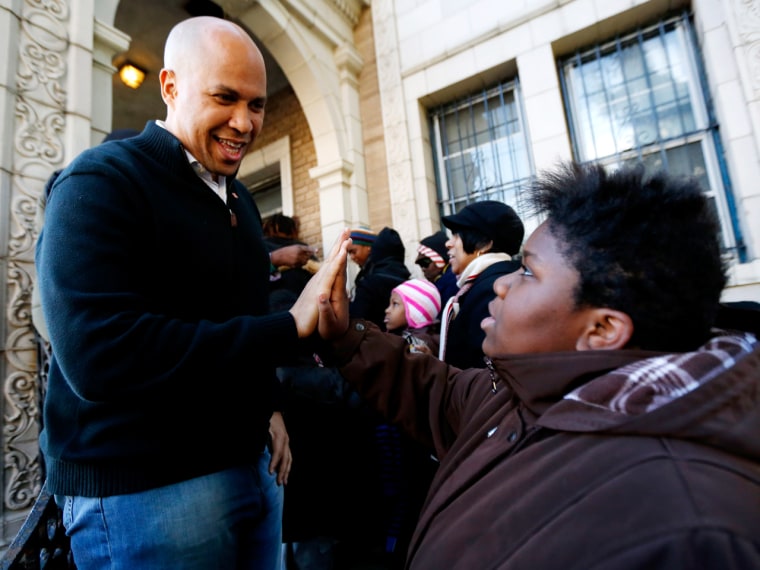 Newark Mayor Cory Booker touches palms with 13-year-old Blonbzell Taylor on Nov. 9, in Newark, N.J. Booker is living as a person would on food stamps by limiting himself to $1.40 for each of his meals, starting Tuesday.