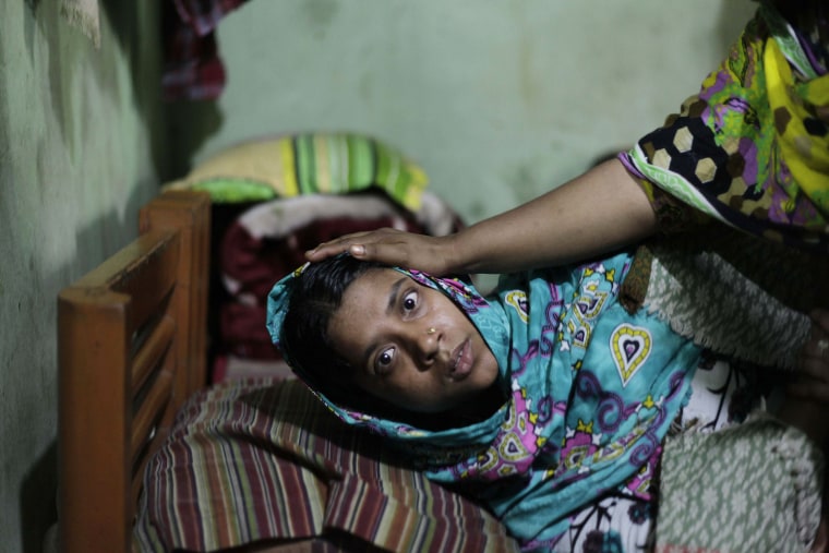 Tahera Begum, 25, lies inside her room in Savar, Bangladesh, Nov. 30. Begum is an operator at the Tazreen Fashions garment factory. Begum became mentally ill and lost her memory after escaping a factory fire on Nov. 24, according to Begum's husband.