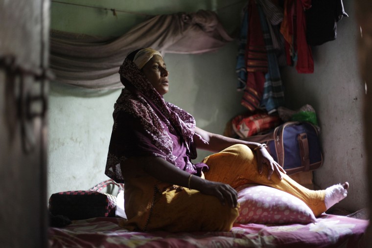 Ale Noor, 35, sits inside her room in Savar, Bangladesh, Nov. 30. Noor is an operator at the Tazreen Fashions garment factory. According to Noor, she broke her left leg after jumping from the fourth floor to escape a factory fire on Nov. 24. Noor earns 3,000 Taka, about $37, per month, but says the factory's workers have had to protest to receive pay each month as the factory's management never paid salaries on time.