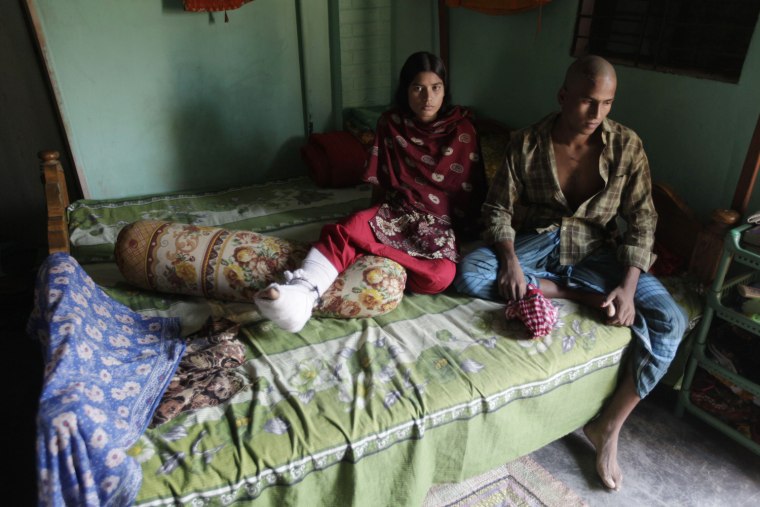 Harun-or-Rashid, 24, sits with his wife Reshma, left, 20, inside their room in Savar, Bangladesh, Nov. 30. Harun and Reshma escaped the Tazreen Fashions garment factory fire that killed more than 100 workers on Nov. 24. According to Reshma, the factory's workers rarely performed fire drills. Reshma broke her right leg after jumping from the third floor to escape the fire. Harun said they will leave their job and return to their hometown in Munshiganj.