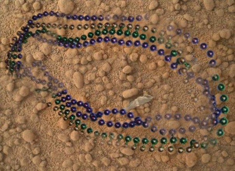 A picture from NASA's Curiosity rover was retouched for a spoof website to look as if Mardi Gras beads were lying on the Martian surface. The whitish-gray object visible in the center of the picture is an actual scrap of plastic that came from Curiosity and was spotted on the ground.